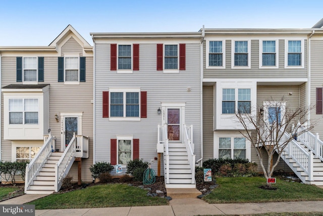 townhome / multi-family property featuring a front lawn