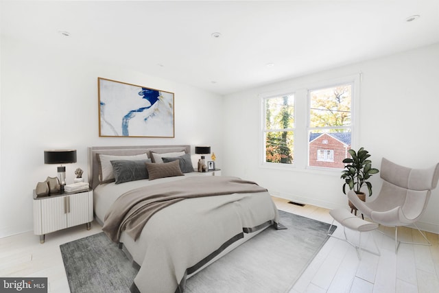 bedroom featuring light wood-type flooring, baseboards, and visible vents