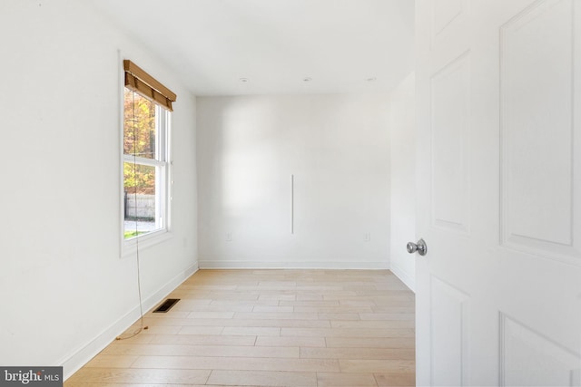 unfurnished room featuring light wood-style floors, baseboards, and visible vents