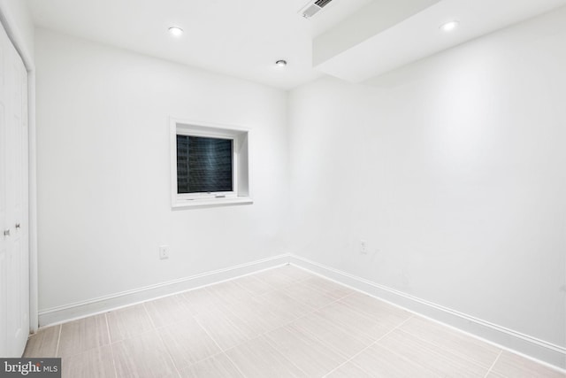 empty room with recessed lighting, visible vents, and baseboards