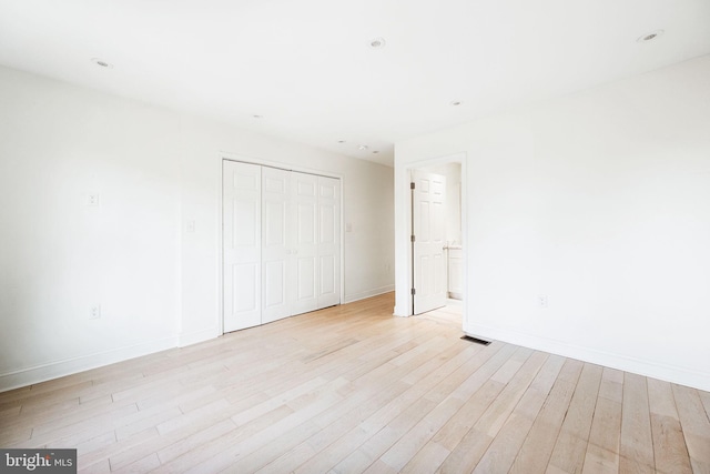 unfurnished bedroom with recessed lighting, a closet, visible vents, light wood-type flooring, and baseboards