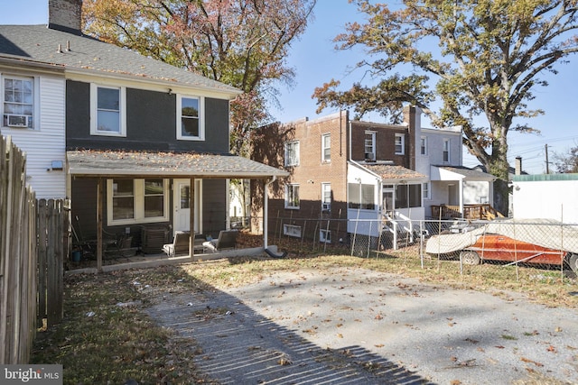 rear view of house featuring a fenced backyard and a chimney