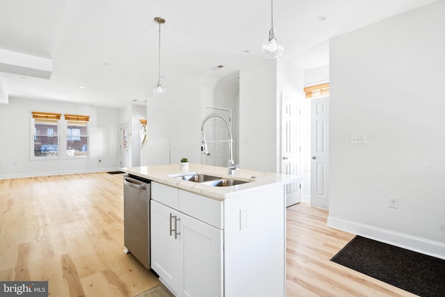 kitchen with open floor plan, white cabinets, a sink, an island with sink, and dishwasher