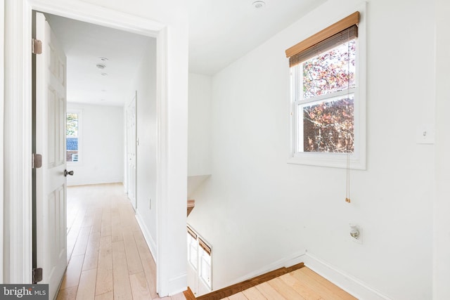 hall with light wood-style floors and baseboards