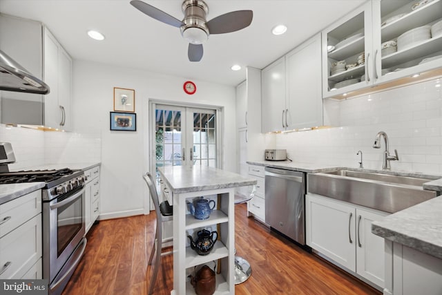 kitchen featuring appliances with stainless steel finishes, french doors, open shelves, a sink, and exhaust hood