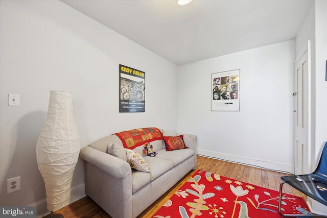 living area featuring baseboards and wood finished floors