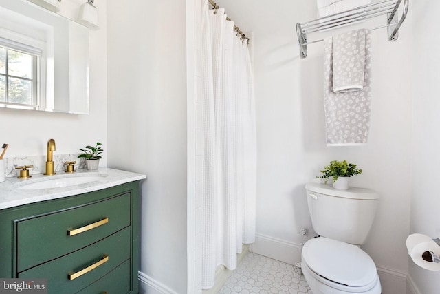 full bathroom with curtained shower, baseboards, vanity, and toilet