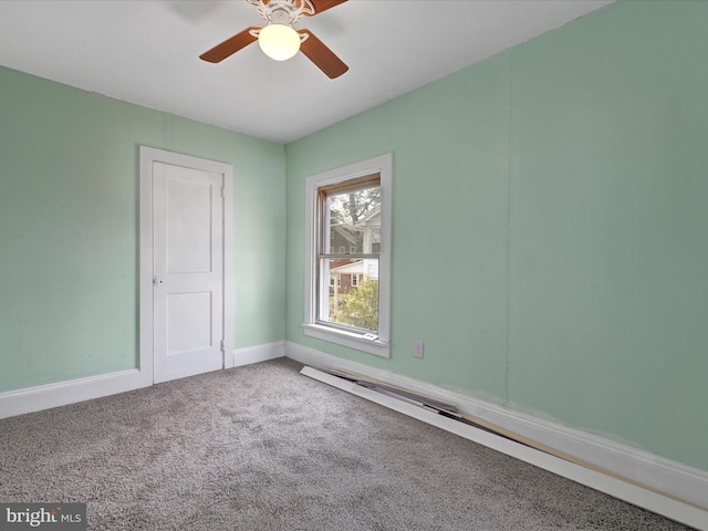 carpeted empty room featuring baseboards and a ceiling fan