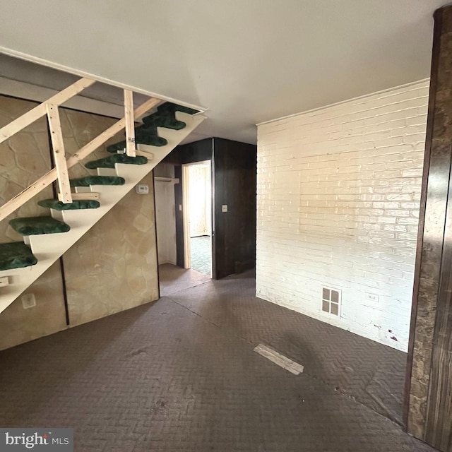 interior space with stairway, brick wall, and visible vents