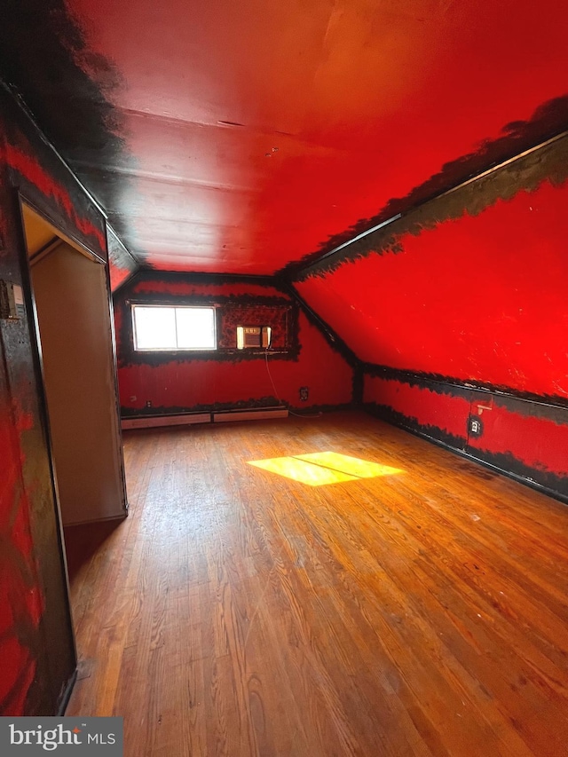 bonus room with hardwood / wood-style flooring, a baseboard radiator, and vaulted ceiling