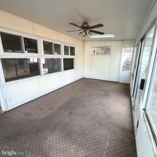 unfurnished sunroom featuring a ceiling fan