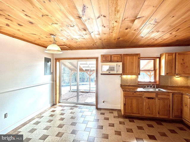 kitchen with white microwave, a sink, wood ceiling, electric panel, and brown cabinetry