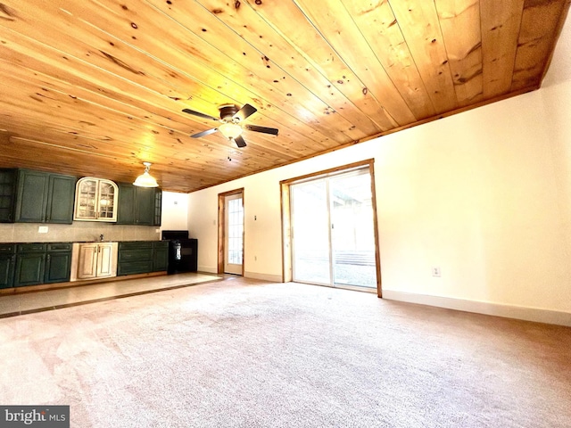 unfurnished living room featuring baseboards, ceiling fan, wood ceiling, and light colored carpet