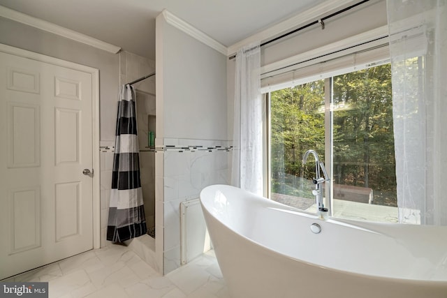 bathroom featuring tile walls, a freestanding bath, marble finish floor, ornamental molding, and a shower with curtain