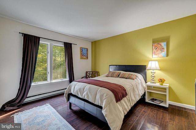 bedroom with baseboard heating, wood finished floors, and baseboards