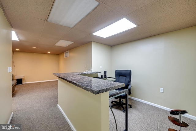 carpeted home office with a paneled ceiling and baseboards