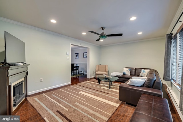 living room featuring recessed lighting, dark wood-type flooring, a fireplace, baseboards, and ornamental molding