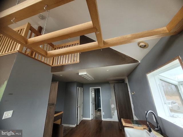 kitchen with a towering ceiling, baseboards, dark wood finished floors, and a sink