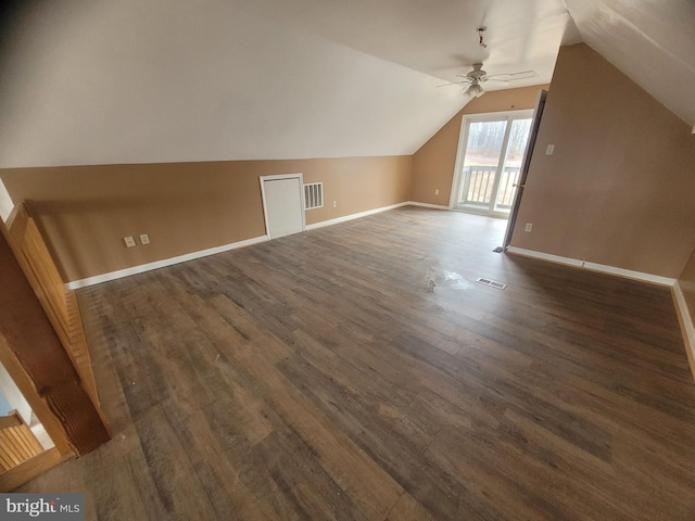 additional living space with lofted ceiling, dark wood-style flooring, visible vents, and baseboards