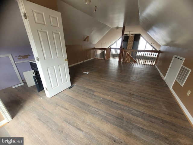 additional living space with baseboards, visible vents, a ceiling fan, lofted ceiling, and wood finished floors