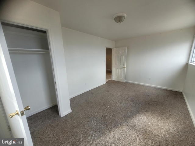 unfurnished bedroom featuring carpet floors, a closet, and baseboards