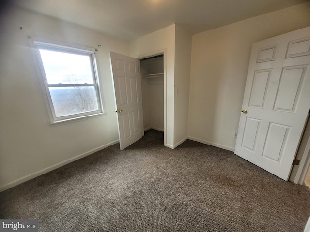 unfurnished bedroom with carpet, baseboards, and a closet