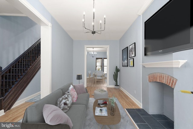 living area featuring wood finished floors, stairway, baseboards, and an inviting chandelier