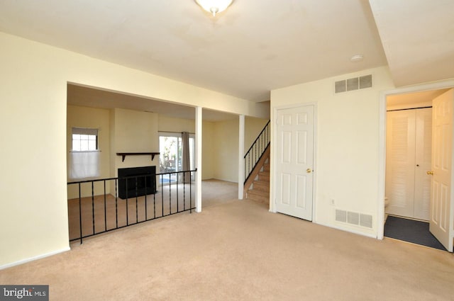 spare room featuring carpet, visible vents, and stairs