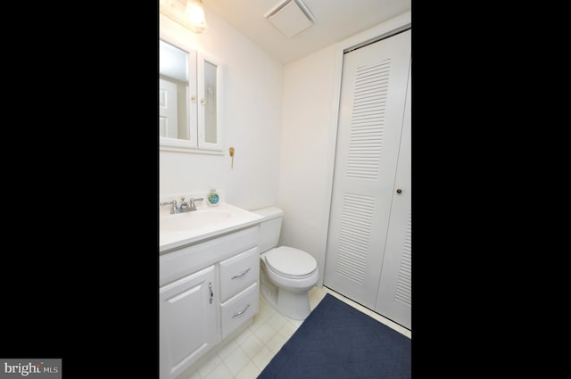 bathroom featuring tile patterned flooring, vanity, and toilet