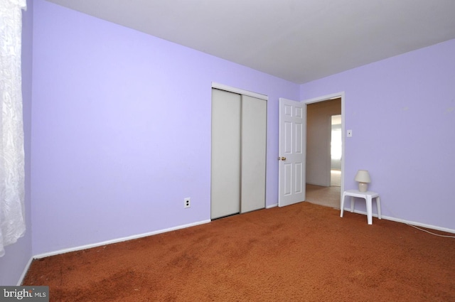 unfurnished bedroom with carpet floors and a closet