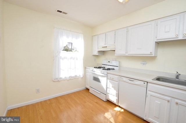 kitchen with under cabinet range hood, white appliances, a sink, visible vents, and light wood finished floors