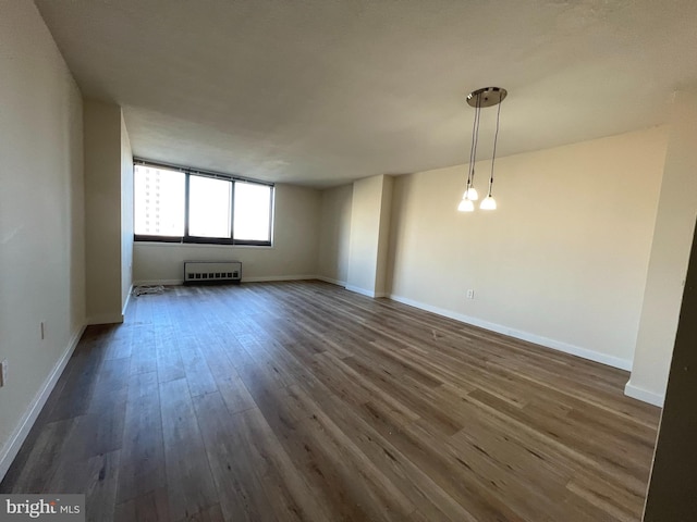 spare room with dark wood-type flooring and baseboards