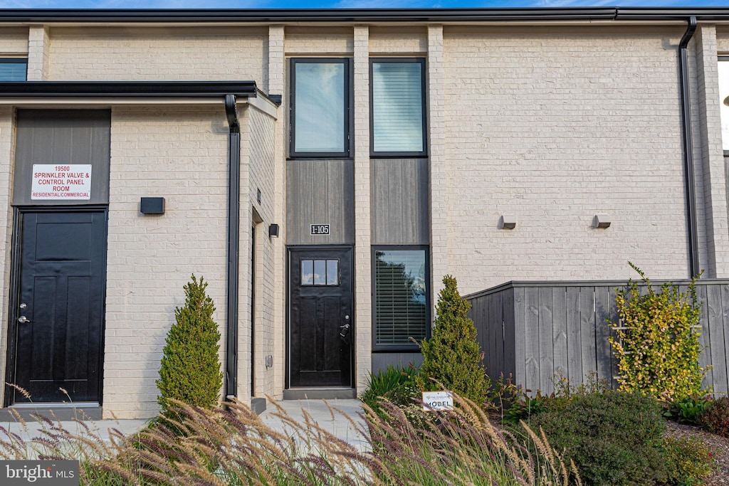 entrance to property featuring brick siding