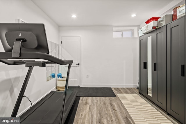 workout room with recessed lighting, baseboards, and wood finished floors