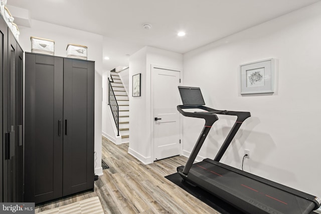 exercise area with recessed lighting, light wood-type flooring, and baseboards