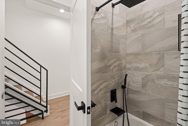 full bathroom with shower / bath combo with shower curtain, baseboards, and wood finished floors