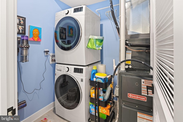 laundry room featuring baseboards, stacked washer and clothes dryer, and laundry area