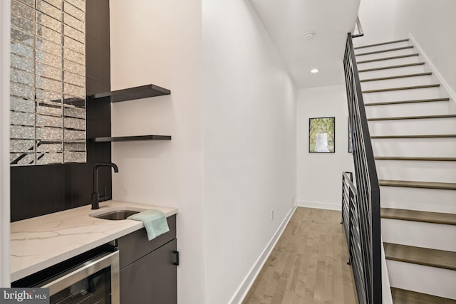 interior space featuring wood finished floors, recessed lighting, wine cooler, wet bar, and baseboards