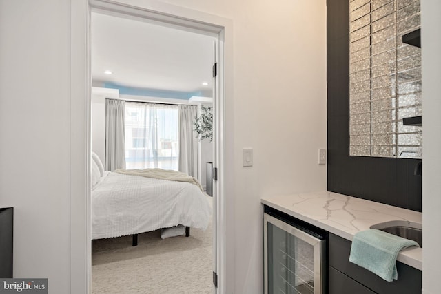 bedroom featuring beverage cooler and carpet