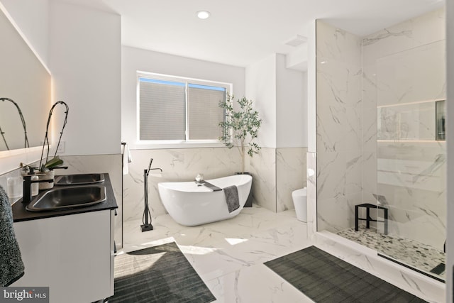 full bath featuring a marble finish shower, a freestanding bath, recessed lighting, marble finish floor, and vanity