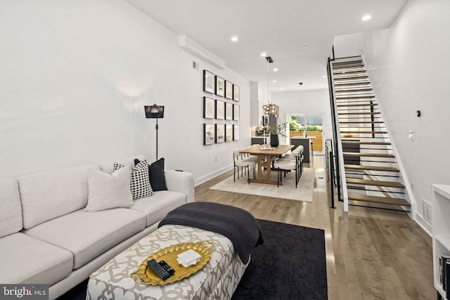 living area with recessed lighting, stairway, baseboards, and wood finished floors