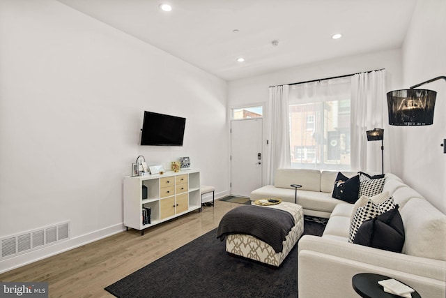 living area with recessed lighting, baseboards, visible vents, and light wood finished floors