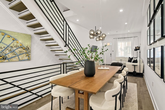 dining space with recessed lighting, a chandelier, wood finished floors, and stairs