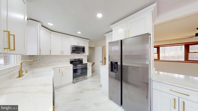 kitchen featuring white cabinets, tasteful backsplash, marble finish floor, and stainless steel appliances