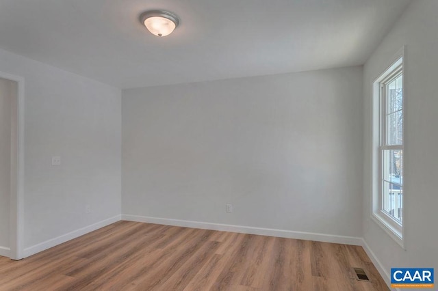 unfurnished room with baseboards, visible vents, and light wood-style flooring