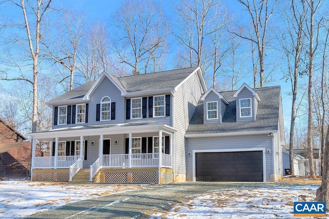 colonial-style house featuring a garage, a shingled roof, a porch, and aphalt driveway