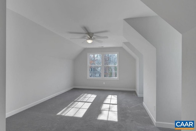 bonus room with vaulted ceiling, ceiling fan, dark carpet, and baseboards