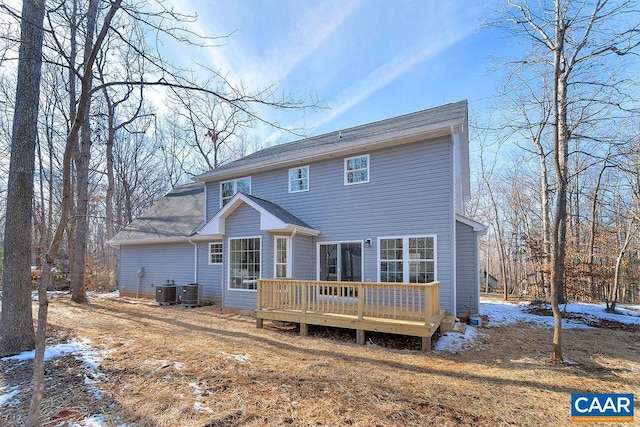 snow covered property with a wooden deck and central air condition unit