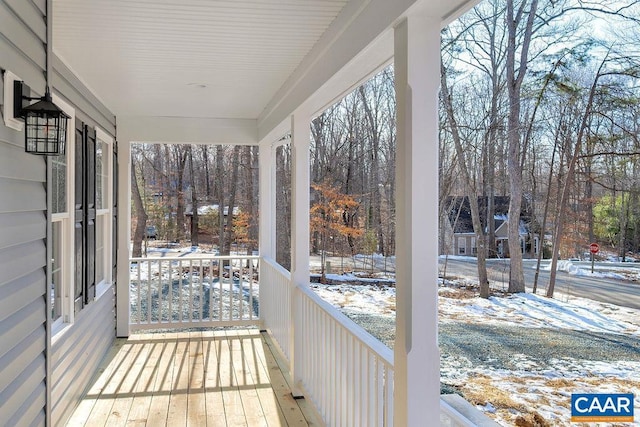 snow covered deck with covered porch