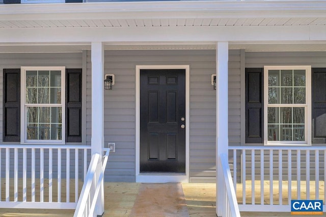 view of exterior entry featuring covered porch